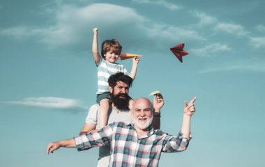 Erkekler nesil: Büyükbaba baba ve torunu kamera bakarak ve gülümsüyor sarılmak vardır. Baba ve oğul açık zevk. Aile halkı.