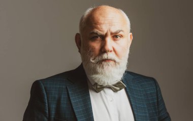 Kıdemli Takım Elbiseli Adam. Sakallı, orta yaşlı bir adamın portresi gri stüdyo arka planında fotokopi alanı olan bir adamın..
