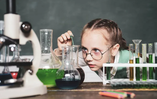 Terug naar school en thuisonderwijs. Wetenschap en onderwijs. Gelukkige kleine wetenschapper die experimenteert met reageerbuis. Portrair close-up. — Stockfoto