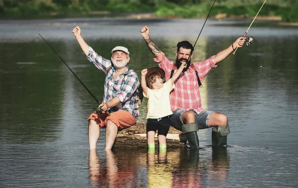 Excited grandfather, father and son are fly fishing on river. — Foto de Stock
