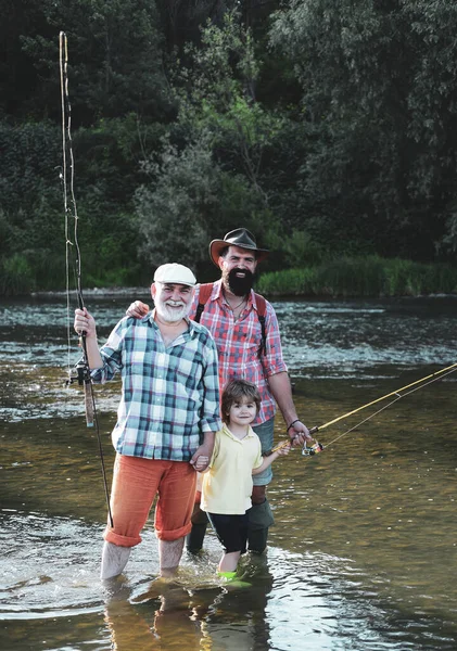 Nonno e padre con ragazzo bambino carino stanno pescando. Un legame familiare. Padre, figlio e nonno che pescano. Giorno di uomini . — Foto Stock