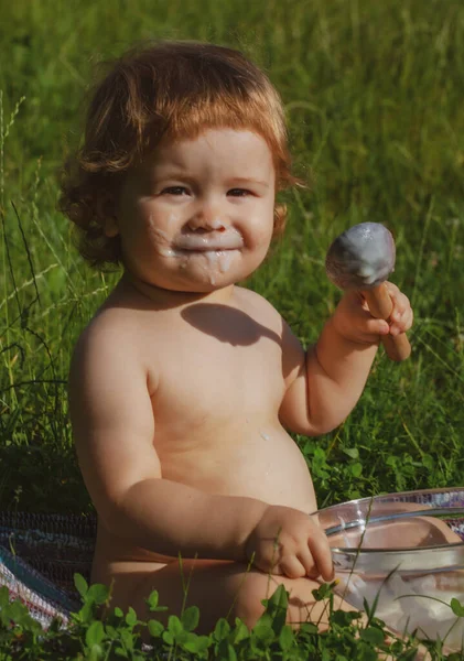 Schattige kleine baby wordt gevoed met lepel. Zorgeloze jeugd in het dorp. — Stockfoto