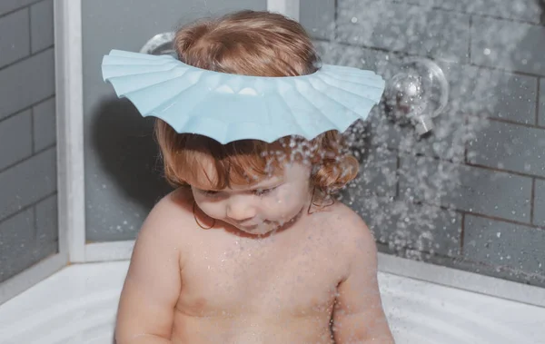 Il bambino in bagno gioca con schiuma. Il bimbo felice divertente si bagna in vasca da bagno con acqua e schiuma. igiene dei bambini. — Foto Stock