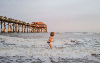 Çocuk yaz tatilinde plajda oynuyor. Tatlı çocuk yazın kumsalda eğleniyor..