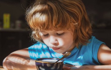 Çocukların beslenmesi. Küçük çocuk çorba içiyor. Çocuklar için sağlıklı yiyecekler. Organik ev yemeği..