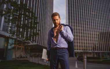 Takım elbiseli beyaz iş adamı ofisten çıkıyor. Son çalışma günü konsepti. Seksi moda işadamı.