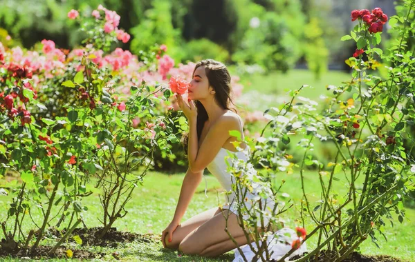 Φυσικά καλλυντικά ομορφιάς και αρώματος. Ανοιξιάτικη γυναίκα στο Ρόουζ Φιλντ. Αισθησιακό κορίτσι σε εξωτερικούς χώρους σε κήπο με τριαντάφυλλα. Γυναίκα απολαμβάνουν υπαίθρια αναψυχή. — Φωτογραφία Αρχείου