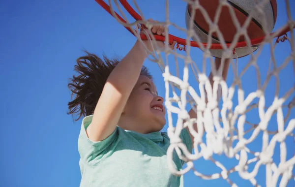 Basket barn spel. Söt liten pojke håller en korg boll försöker göra en poäng. — Stockfoto