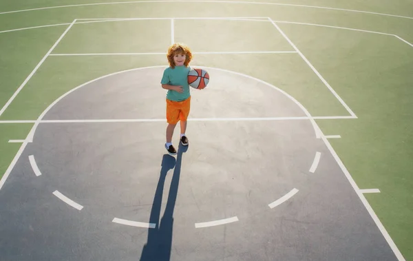 Basket barn spel. Söt liten pojke håller en korg boll försöker göra en poäng. — Stockfoto