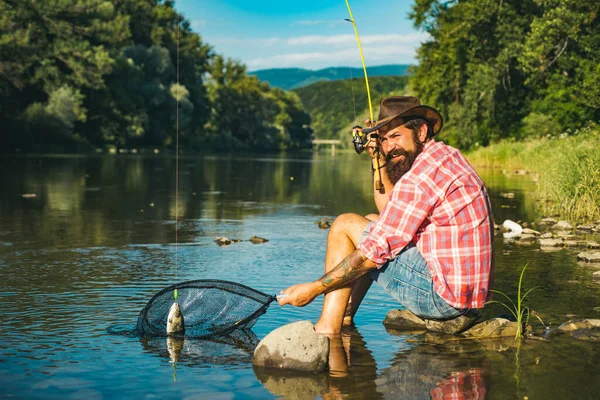 Fischer fing einen Fisch. Mann fischt auf Fluss. — Stockfoto