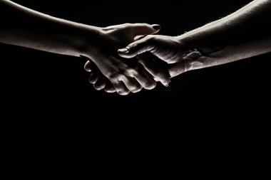 İki ortak arasında tokalaşma. Kurtarmak ya da el hareketlerine yardım etmek. Kurtuluş kavramı. Kurtarma sırasında iki kişinin elleri, anlaşma, yardım. Siyah arkaplanda izole.
