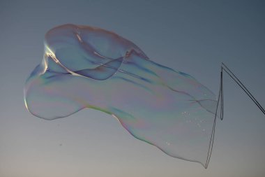 Gökkuşağı yansımalı sabun köpükleri. Mavi gökyüzünde kabarcıklar. Baloncuk partisi.