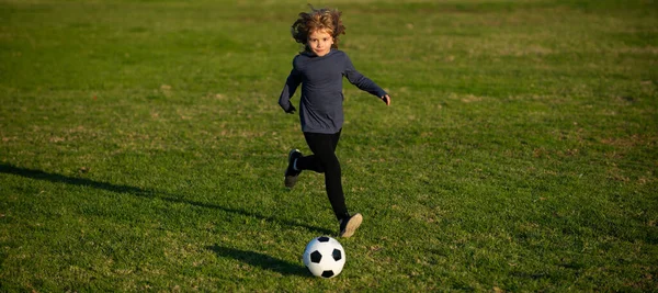 Młody chłopak kopie piłkę. Piłkarz w ruchu, chłopiec w ruchu. Dziecko grające w piłkę nożną, szczęśliwe dziecko cieszące się sportowym meczem piłki nożnej, zajęcia dla dzieci, mały piłkarz. — Zdjęcie stockowe