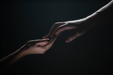 İki elle. Bir arkadaşa yardım ediyorum. Kurtarmak ya da el hareketlerine yardım etmek. Kurtuluş kavramı. Kurtarma sırasında iki kişinin elleri, yardım edin. Siyah arka planda izole edilmiş. Şefkat, şefkat dokunuşu.