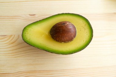 Ahşap zeminde avokado ve avokado parçaları.
