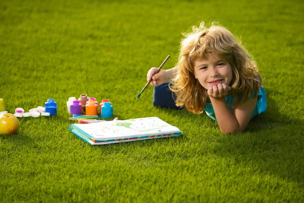 Τα παιδιά δημιουργούν καλλιτέχνης ζωγραφίζει διακοπές δημιουργικότητας. Πορτρέτο του χαμογελαστού χαρούμενος παιδί απολαμβάνοντας την τέχνη και την τέχνη σχέδιο στην πίσω αυλή ή άνοιξη πάρκο. Παιδική ζωγραφιά με μολύβια εξωτερική. — Φωτογραφία Αρχείου