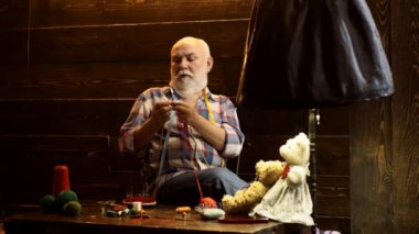 Örgü şişleri olan yaşlı bir adam. Örgü iğnesi, iplik nakış işi. Emeklilik toplantısı konsepti.