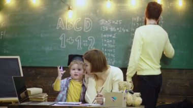 Schoolboy kids at elementary school. Cute little kid boy learning with parents. Mother father and children drawing at home school class.