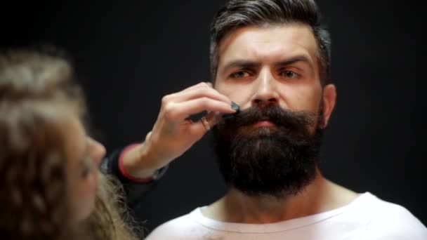 Cutting long beard. Bearded man in a barbershop. trendy cut beard. shaving beard. Barber Shop procedures. Woman cuts hair with scissors. Man with long beard, mustache and stylish hair. — Wideo stockowe