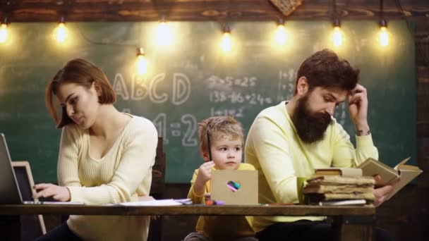 Escuela familiar y educación en el hogar de los niños. Mamá y papá con el niño escribiendo en la escuela en casa. Educación concepto de la familia y la tarea, madre padre feliz y el hijo escribiendo a la libreta en la clase en casa. — Vídeo de stock