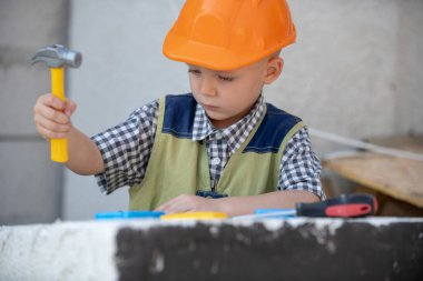 Child in building helmet, hard hat. Child dressed as a workman builder. Portrait little builder in hardhats. Little builder in helmet. Kids builder and repair.