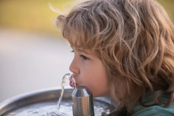 옥외에 있는 분수에서 물을 마시는 어린이. — 스톡 사진
