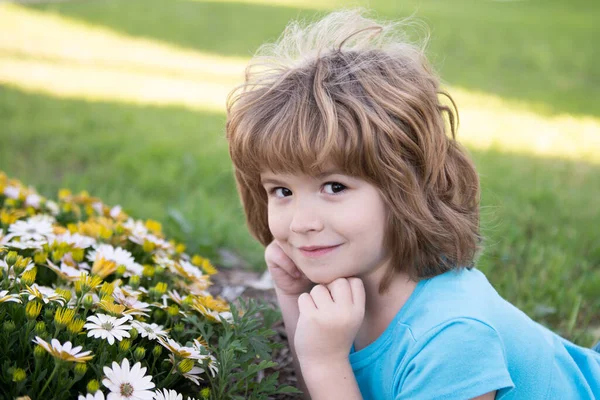 Retrato de criança bonita no jardim florescente de verão. Um miúdo feliz no prado com flores brancas. Noite quente de verão. Crianças e natureza. — Fotografia de Stock