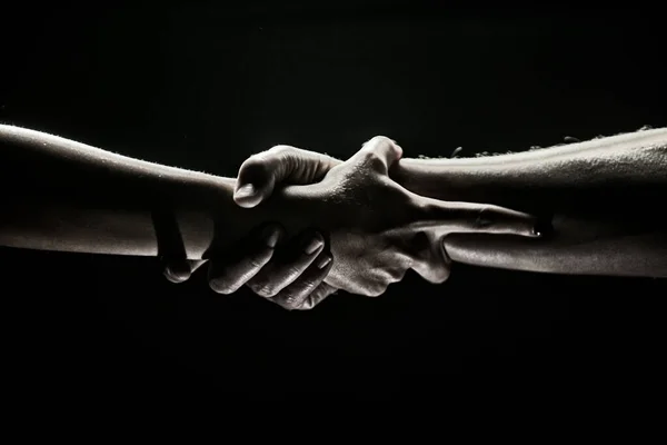 Manos haciendo gestos sobre fondo negro. Echando una mano. Apoyo y ayuda, salvación. Fuerza fuertes pelos de dos personas en el momento del rescate. Mano de ayuda extendida para la salvación. Fuerte sujeción. —  Fotos de Stock