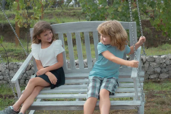 İki çocuk yaz parkında dinleniyor. Erkek ve kız kardeş mutlu bir şekilde doğada yürüyor. Kardeşler bahçede oynuyorlar..