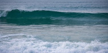 Mavi okyanus dalgaları, okyanus dalgaları, doğal arka plan. Mavi, temiz, dalgalı deniz suyu. Deniz köpüğü..