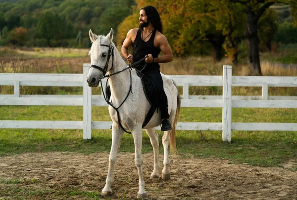 Handsome muscular man riding horse. Hunky cowboy. Young muscular guy in t-shirt on horseback. — Photo