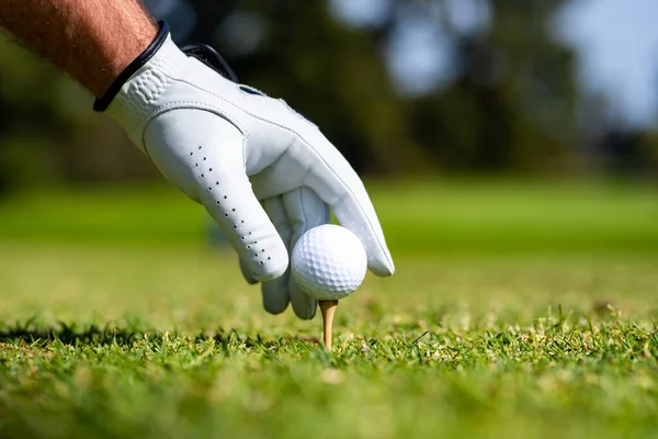 Golfer slaat golfbal met club op koers. Hand met golfhandschoen. — Stockfoto