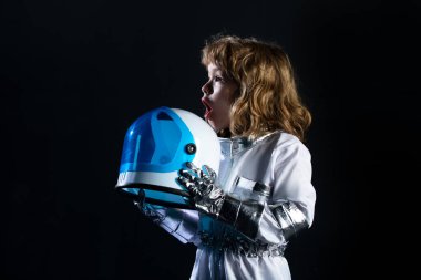 Uzay kaskı ve metal kıyafetiyle astronot olmak için oynayan heyecanlı çocuk..