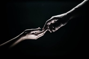Two hands reaching toward. Tenderness, tendet touch hands in black background. Romantic touch with fingers, love. Hand creation of adam.