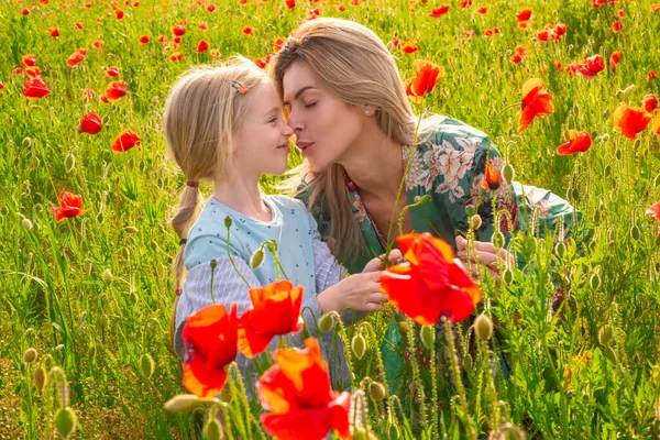 Anne ve kızı gelincik çayırında. Haşhaş tarlasında güzel bir anne ve kız. Gelincik çiçekleri.