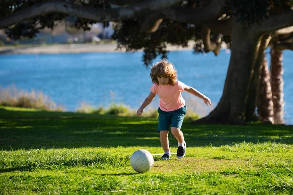 Boy child kicking football on the sports field during soccer match. — Zdjęcie stockowe