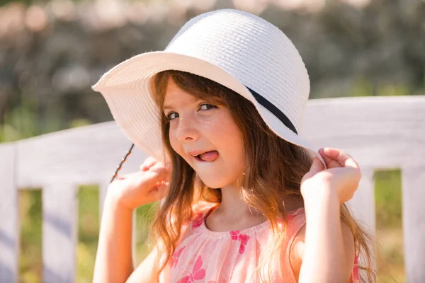 Funny kids face with tongue. Portrait of funny child girl in summer park. Face close up of cute teen girl outdoor. Cute little girl swinging on the meadow in summer day. — Stockfoto