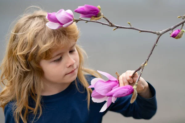 Γοητευτικό ξανθό παιδί σε φόντο λουλουδιών το καλοκαίρι. Όμορφο μικρό παιδί που εργάζεται στον κήπο, παιδί που φροντίζει τα λουλούδια, απολαμβάνοντας ζεστή και ηλιόλουστη μέρα. — Φωτογραφία Αρχείου