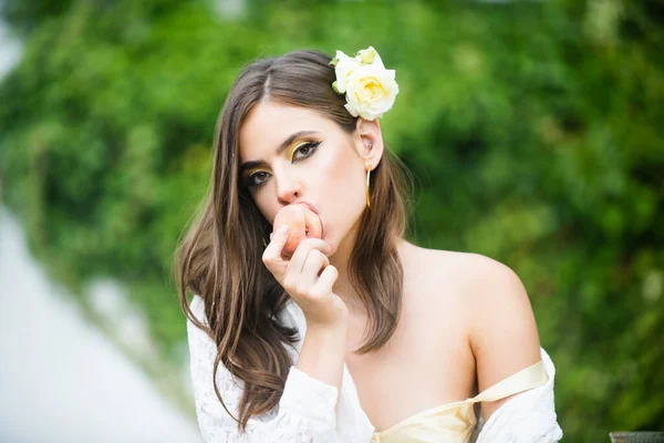 Retrato de mujer joven sexy comiendo melocotón, contra el fondo del parque verde de verano. —  Fotos de Stock