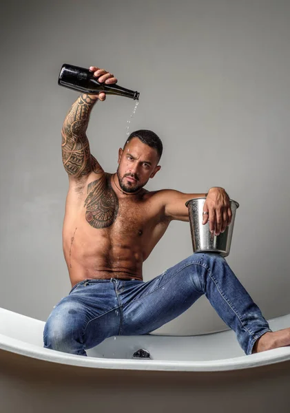 Sexy seductive undress man sit on bathtub in bathroom, men holiday with champagne. Celebrating christmas or birthday. Private sex party. Hot topless boy on womans day. — ストック写真