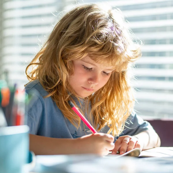 Een kind dat huiswerk schrijft in de klas. Een kleuter die thuis huiswerk maakt. Kinderstudie. Onderwijs en leren voor kinderen. Schattig jongetje doet huiswerk in de klas. — Stockfoto