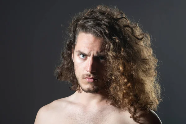Man with curly hair. Close up portrait of attractive modern handsome muscular brunette man with perfect curly hair isolated on gray background copy space. — Photo