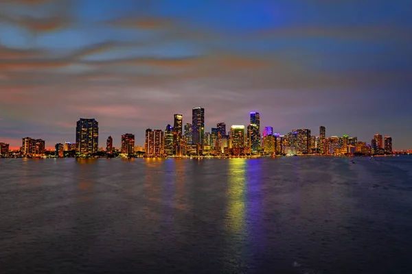 Miami, Florida városképe a Biscayne-öbölben. Panoráma alkonyatkor városi felhőkarcolók és híd a tenger felett elmélkedve. — Stock Fotó