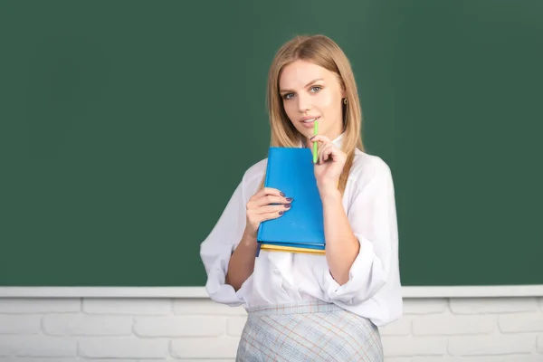 Μαθητής Λυκείου μαθαίνει Αγγλικά ή Μαθηματικά στην τάξη. Μια φοιτήτρια κρατάει σημειώσεις από ένα βιβλίο στο κολέγιο. Σκέψη νεαρή γυναίκα. — Φωτογραφία Αρχείου