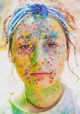 Yaratıcı sanat renginde yüzü olan genç bir kadın. Renkli Holi sıçraması.