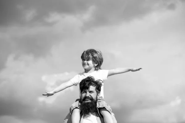 Vater und Sohn spielen zusammen. Kind sitzt auf den Schultern seines Vaters. Familienzeit. — Stockfoto