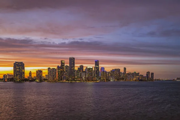 Miami Florida şehri, gün batımında Biscayne Körfezi 'nde iş ve konut binaları ve köprü manzarası. Skyline gece görüntüsü.