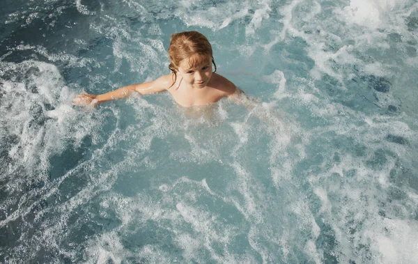 Mosolygós, aranyos kisfiú a medencében. Gyerek játszani a vízben a strandon nyaralás. — Stock Fotó