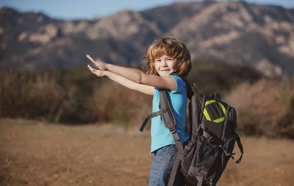 Menino com mochila caminhando em montanhas cênicas. Kid turista local vai em uma caminhada local. — Fotografia de Stock