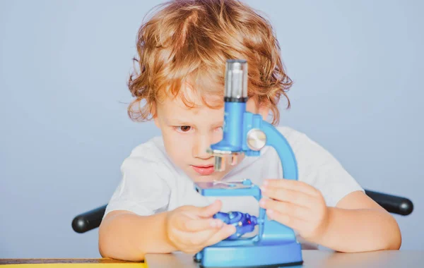 Criança bonito menino brincar com microscópio. Conceito de educação e leitura. — Fotografia de Stock
